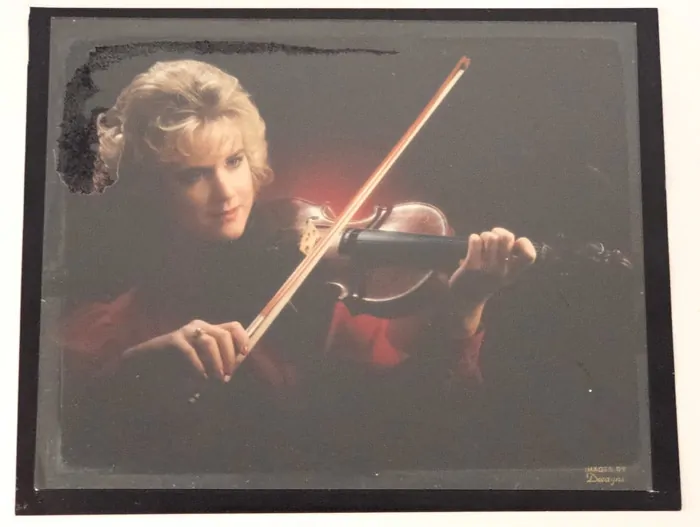 A photograph that is stuck to glass after it has been removed from the frame.
